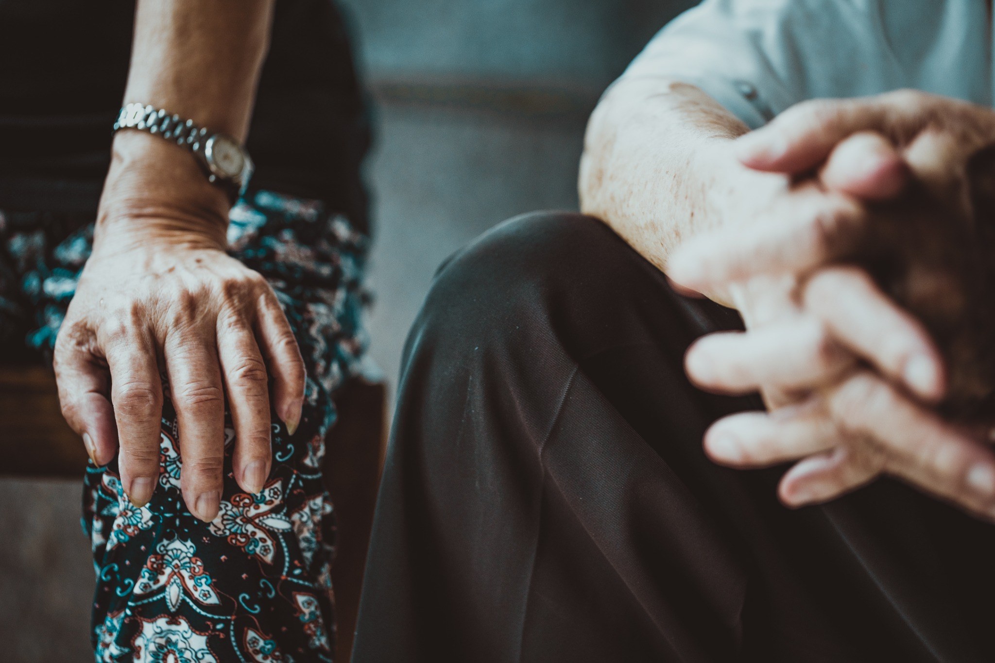 Older couple sitting together and holding hands